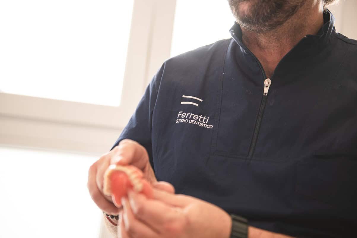 Una protesi dentale tra le mani del medico